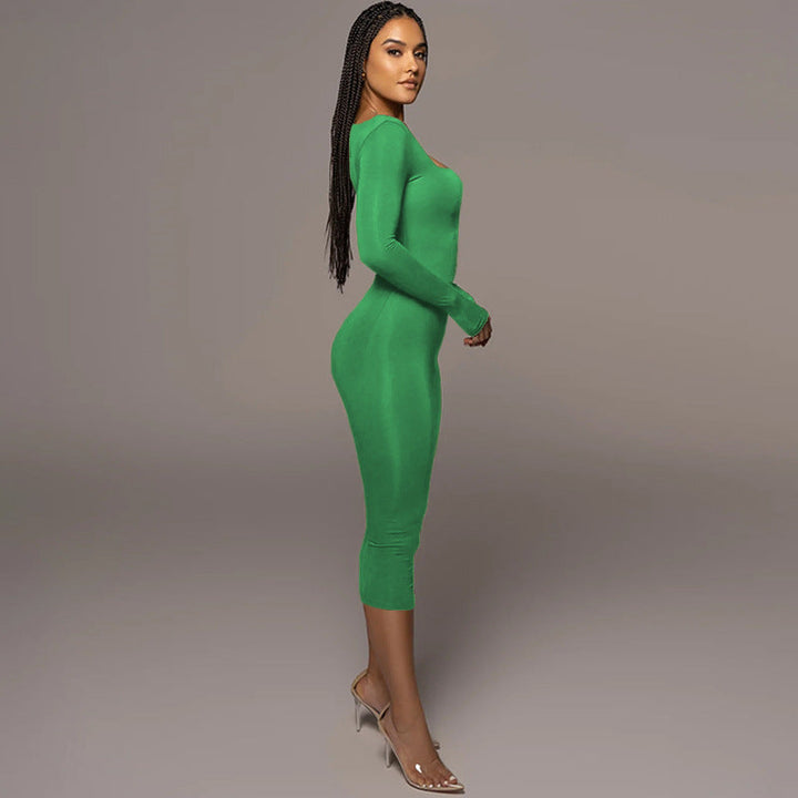 Woman wearing a form-fitting bright green long-sleeved dress and clear high heels.